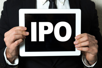Business man holding tablet with the text: IPO