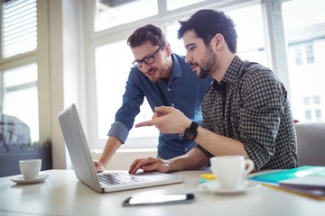 Photo editors discussing using laptop