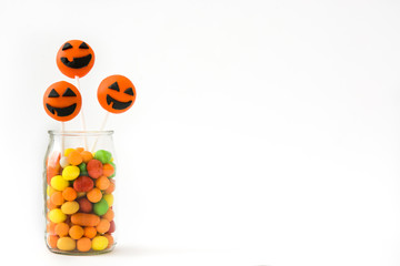 Halloween cake pops and colored candies isolated on white background

