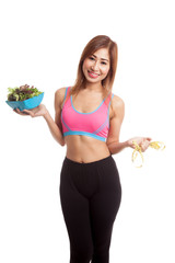 Beautiful Asian healthy girl with measuring tape and salad