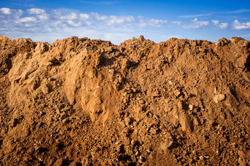 Geological soil cut on blue sky background.