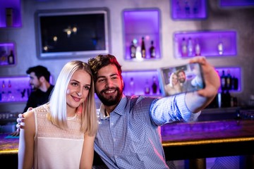 Smiling friends taking a selfie from mobile phone