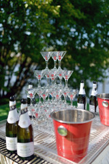 Beautiful wedding slide champagne for bride and groom indoors. Colorful glasses for alcohol with berries. Beauty of bridal interior for marriage. Bright bar for celebration