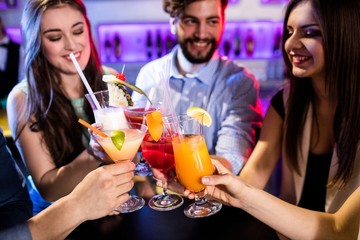 Group of friends toasting cocktail at bar counter