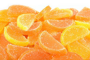 Fototapeta na wymiar Heap of orange and lemon candy slices on a white