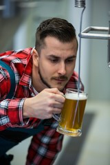 Close-up of brewer testing beer