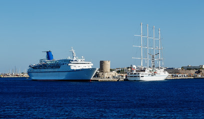 Fototapeta na wymiar cruise ship, and ships with masts and sails into the port of Rhodes