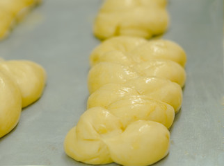 Delicious shiny kringle dough ready for oven lying on metal surface pre cooking