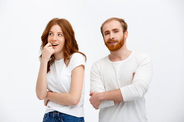 Fototapeta premium Beautiful redhead girl and boy standing over white background