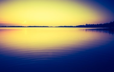 Vintage photo of sunset over calm lake