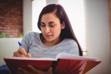 Woman writing on book