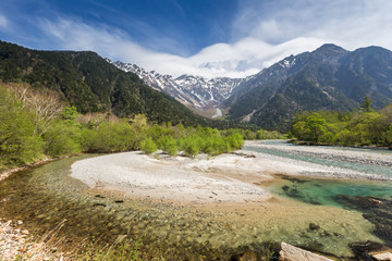 landscape with mountains trees and a river in front