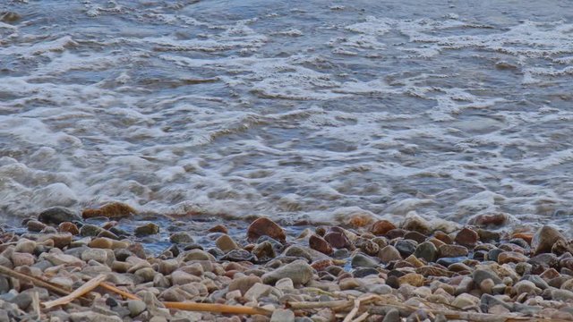 waves wash over the smooth stones