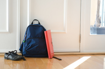 Back to school or ready for school concept with school bag and shoes by front door - obrazy, fototapety, plakaty