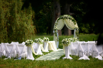 Wedding arch decorated with cloth and vivid flowers