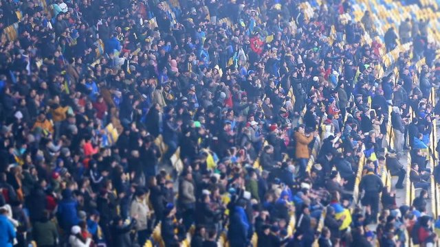 Happy fans applauding footballers at field and leaving stadium, game over