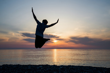 silhouette of teenager jumping in sunset for fun