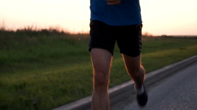 The athlete's body of a runner close-up while Jogging