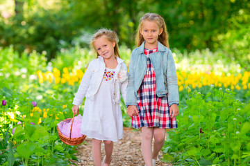 Fototapeta premium Little adorable girls walking in spring garden outdoors