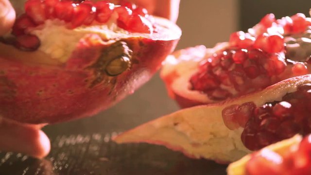 Man breaking a half of pomegranate