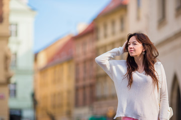 Happy young urban woman in european city. Caucasian tourist walking along the deserted streets of Europe. Warm summer early morning in Prague, Czech Republic