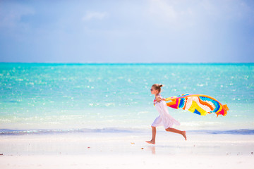 Obraz na płótnie Canvas Little girl have fun with beach towel during tropical vacation