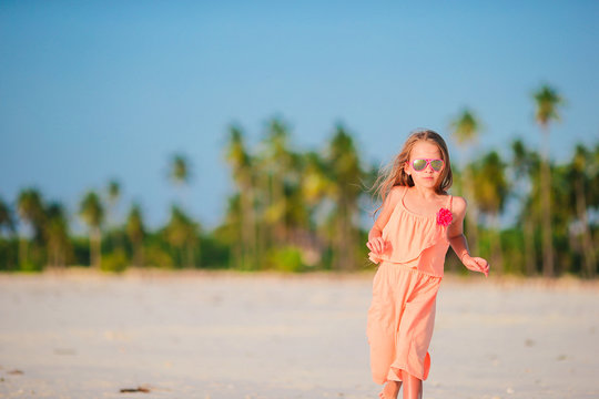 Adorable little girl at tropical beach during vacation