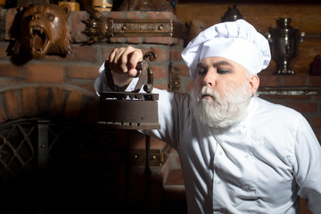 Senior cook with coal iron