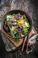 Octopus served with vegetables and noodles