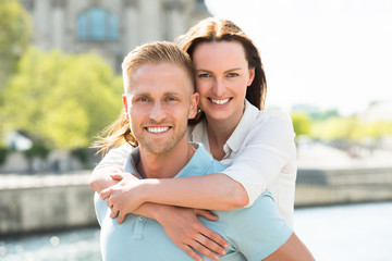 Happy Man Carrying Woman On His Back