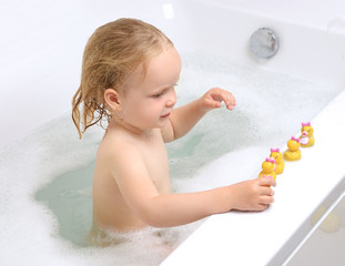 Wet baby girl toddler kid in bathing with soap suds in white bat