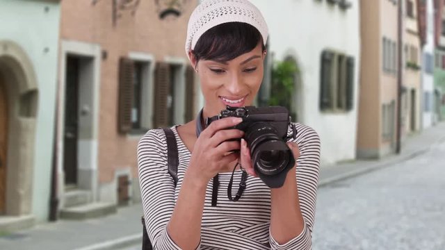 Woman with camera taking photo on Venice Italy city street. Black woman tourist in her 20s traveling on vacation