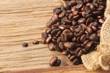 Coffee beans with burlap sack on wood background