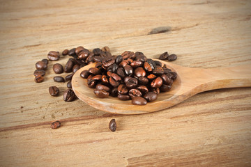 Coffee beans with spoon on wooden table