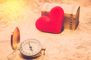 Vintage compassed on travel map and treasure chest and love heart. concept for explore true love © pushish images
