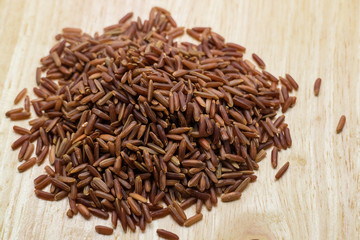 Uncook brown rice on wood background