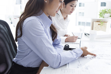 Business women are pointing to the accompanying drawings