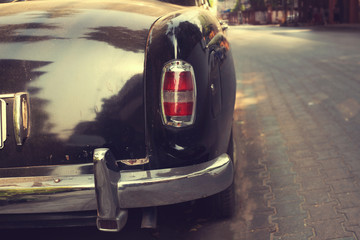 Rear view of classic car parked on road in urban - vintage retro color effect styles