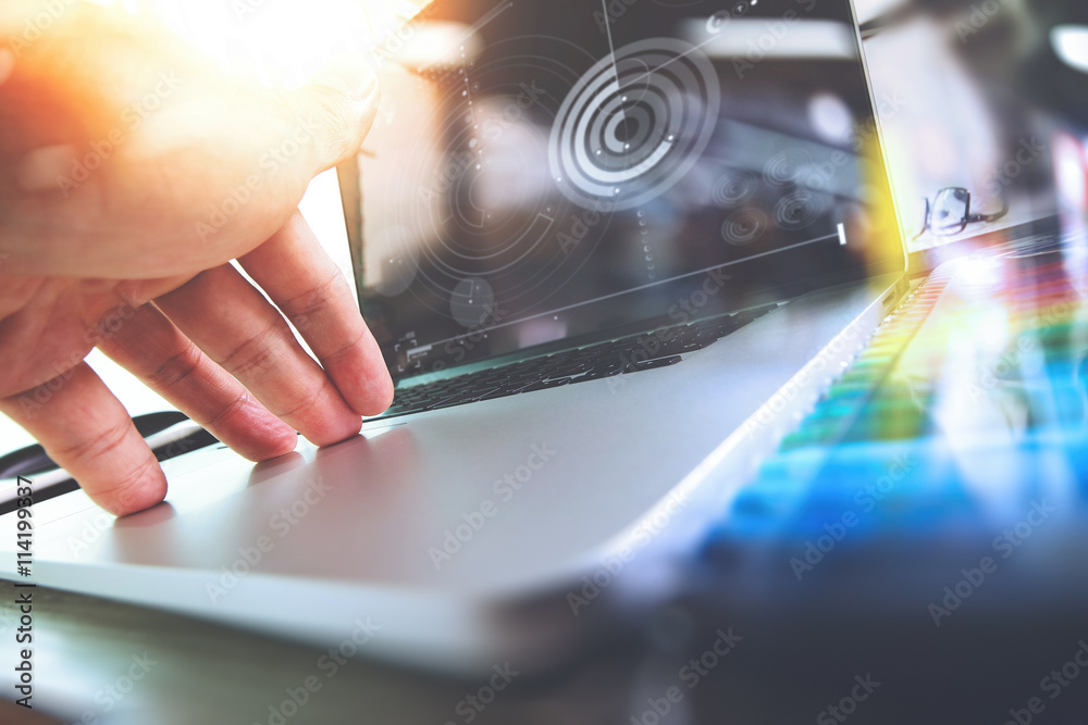Poster designer hand working with laptop computer on wooden desk as res