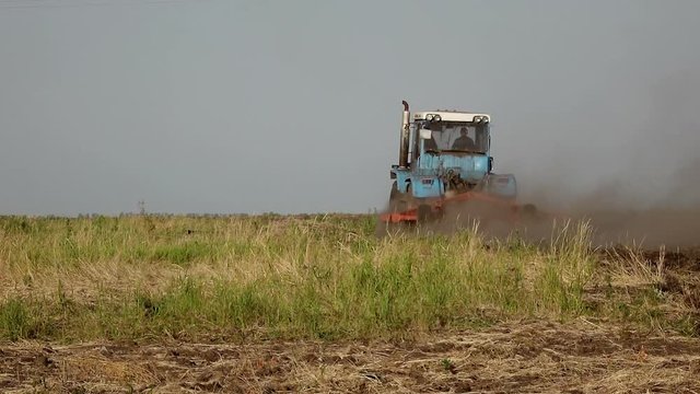 Slow motion video of a Tractor plowing a field in contry side. Full HD stock footage clip.

