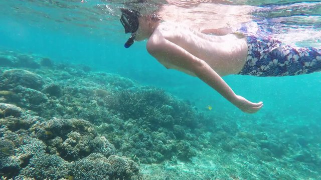Underwater footage of a young boy 12 year snorkeling and diving in a tropical sea in Nusa penida, Indonesia, Bali