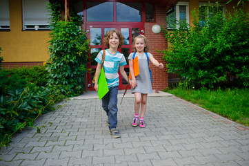 Fototapeta na wymiar Boy and girl go on a schoolyard having joined hands.