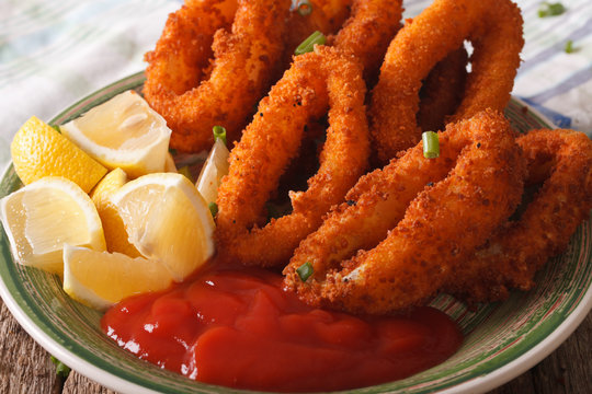squid rings fried in breadcrumbs close-up on a plate with ketchup. horizontal
