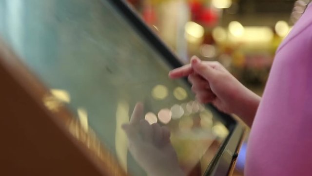 The girl works with a large tablet touchscreen in the Mall
