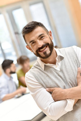Fototapeta premium Confident man in meeting room, people in background