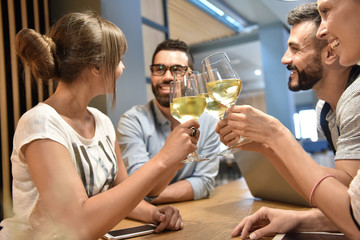 Group of young people cheering with wine glasses