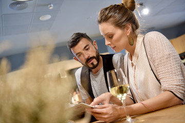 Young trendy people in restaurant looking at menu