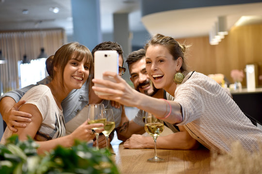 Group of friends taking selfie pictures in bar
