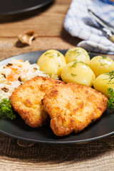 Fried pork chop in breadcrumbs, served with boiled potatoes and