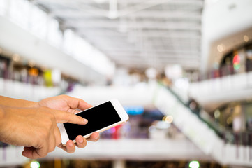 Hand use smartphone on blur shopping mall background